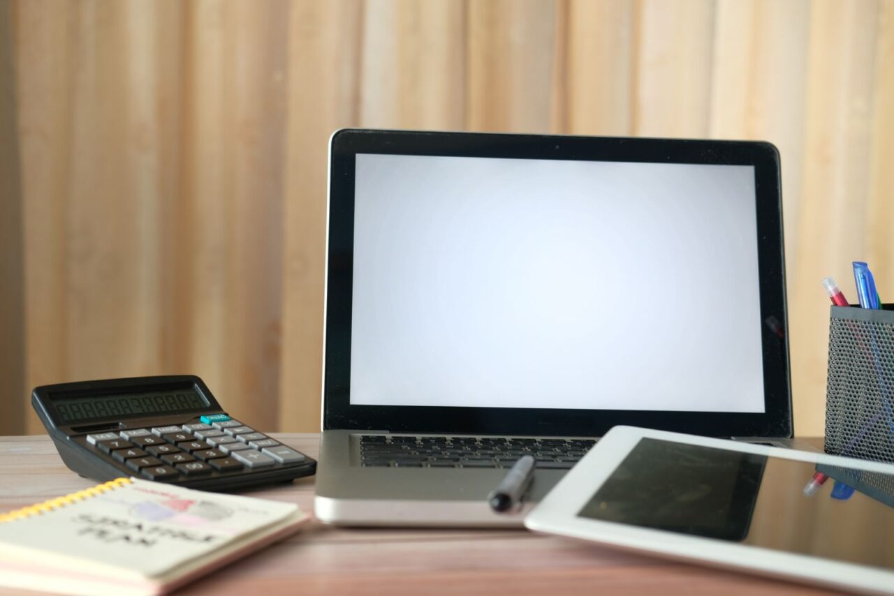 Laptop, calculator and tablet on an office desk, ready for an online registration