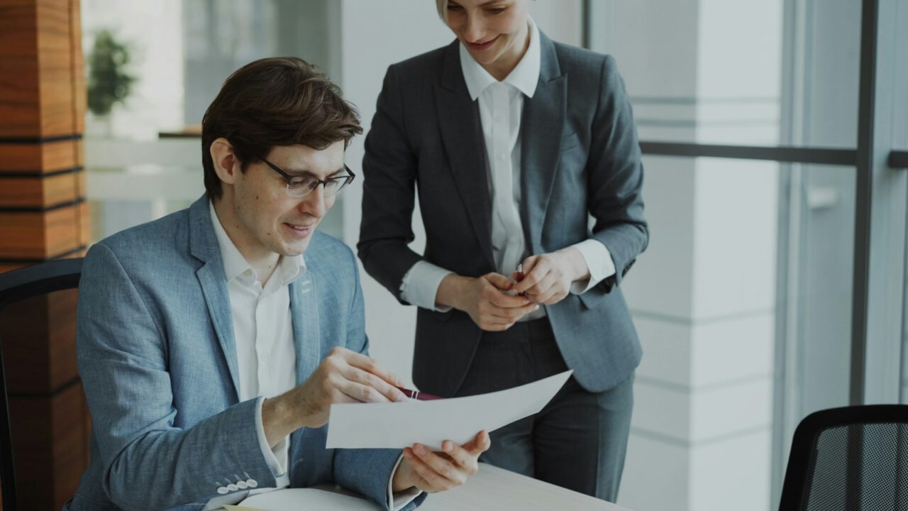 Internal Audit Services in Dubai — section2 Manager in a suit reviewing a report at his desk while a colleague stands beside him