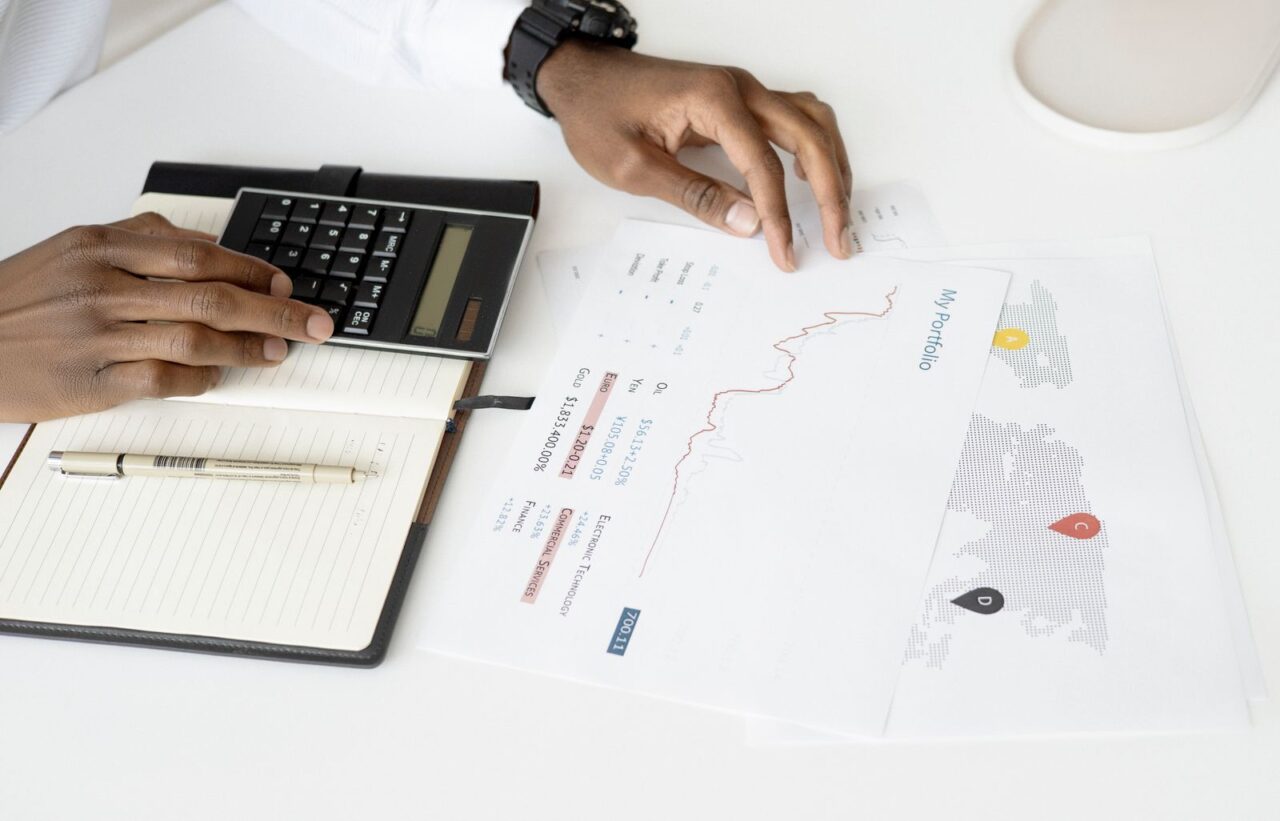 VAT Services in Dubai — section1 Hands using a calculator next to printed financial reports and a notebook on a white desk